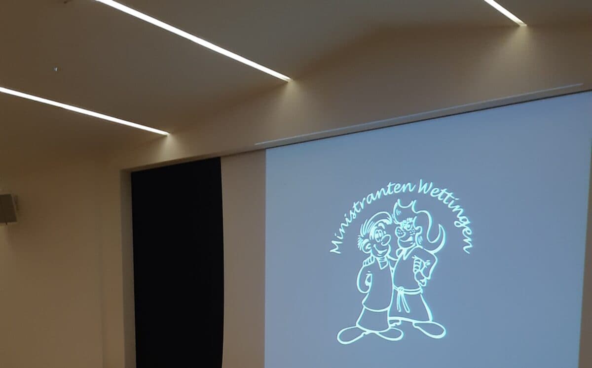 Leinwand im Pfarreisaal mit dem Logo der Ministranten Wettingen