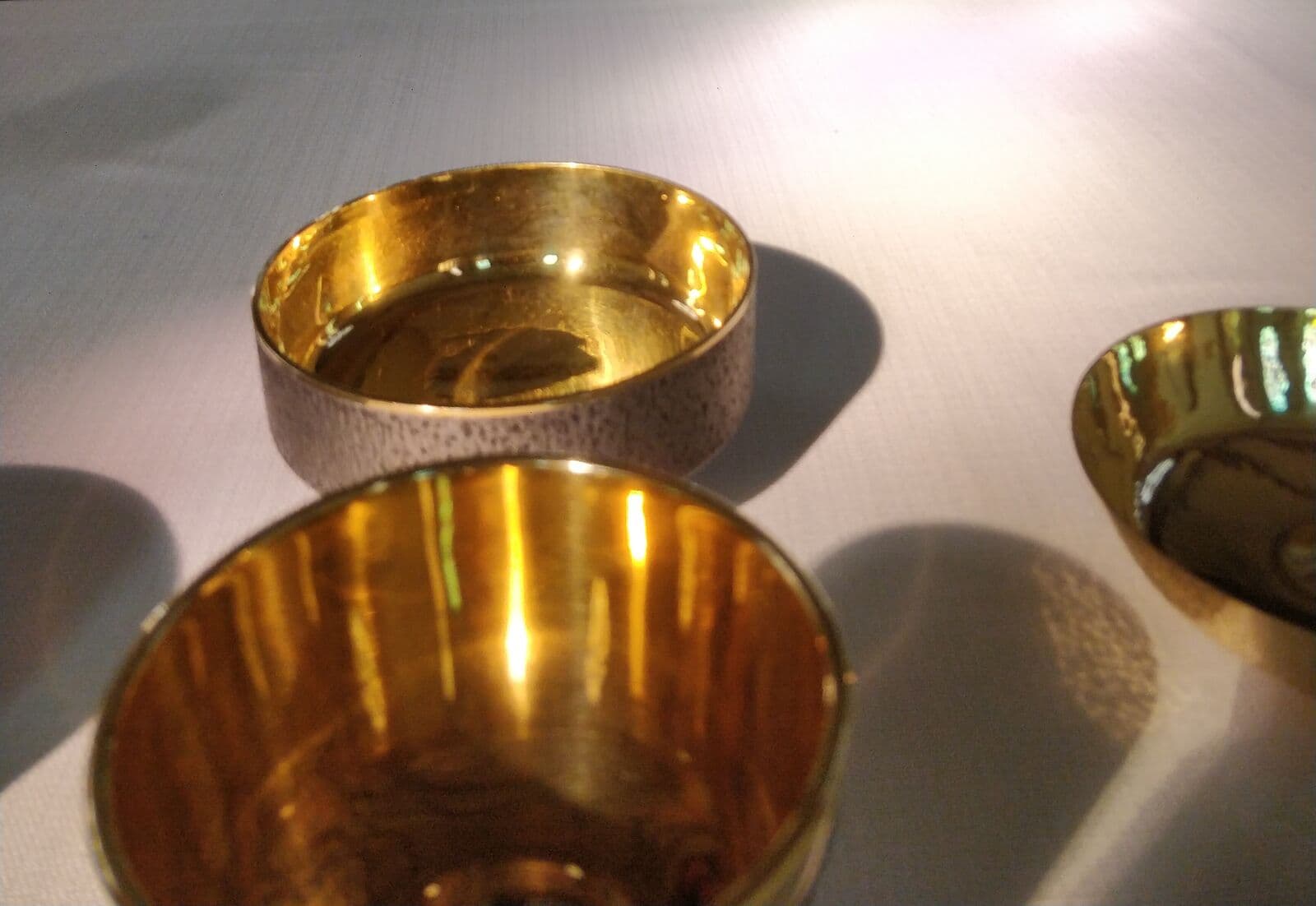 Goldene Kelche und Schalen auf dem Altartuch