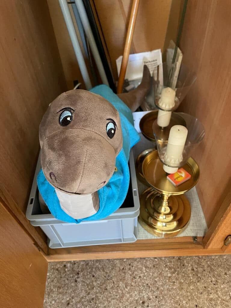 Das Plüschmaskottchen der Tarzisius Games neben einem Kerzenständer